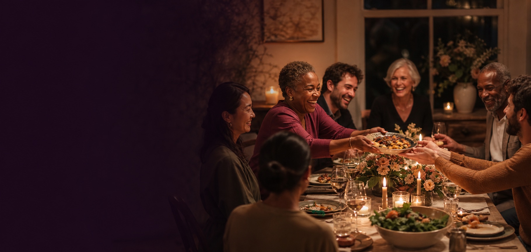 A candlelit dinner table surrounded by friends