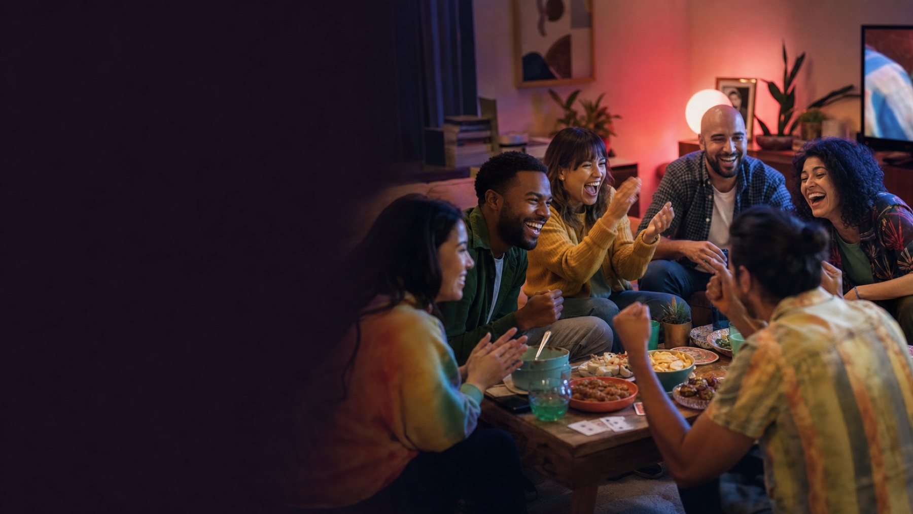 Friends laughing over snacks and cards